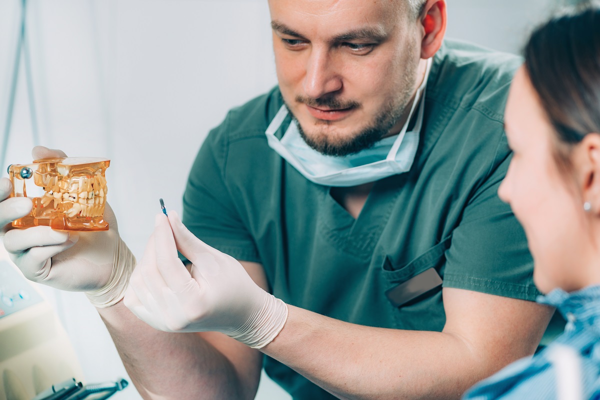 Стоматолог пояснює процедуру імплантації зубів пацієнту в клініці