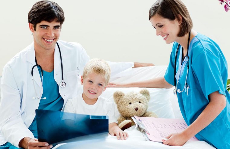 Детская хирургия, маленький мальчик смотрит рентгеновский снимок вместе со своим врачом и медсестрой