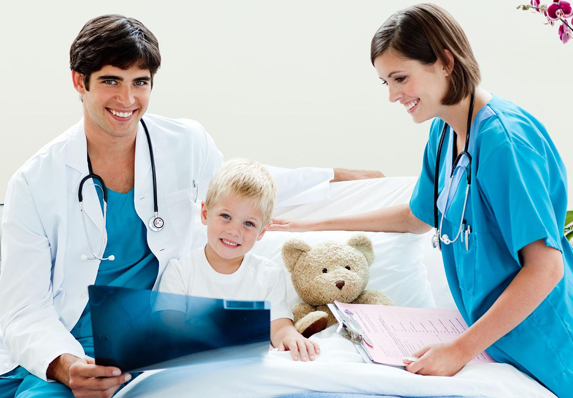 Детская хирургия, маленький мальчик смотрит рентгеновский снимок вместе со своим врачом и медсестрой