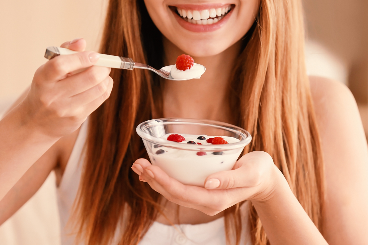 Девушка кушает йогурт