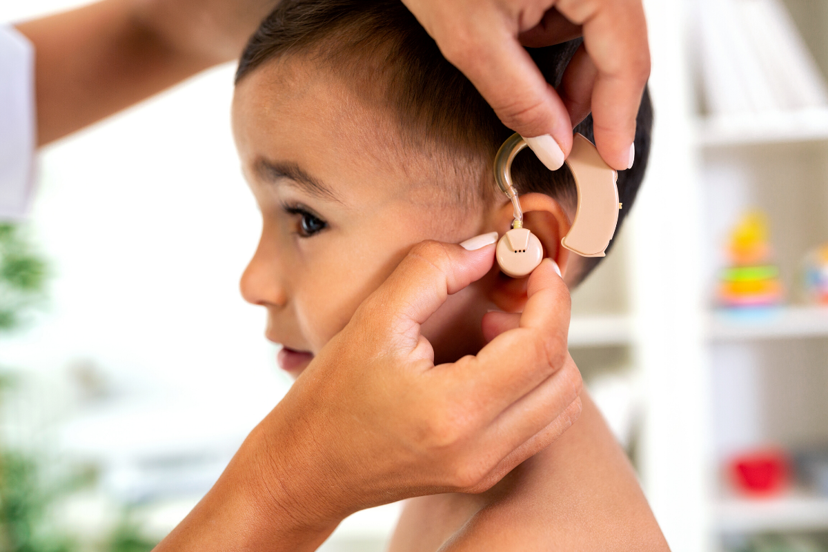 Лікар підбирає слуховий апарат для дитини