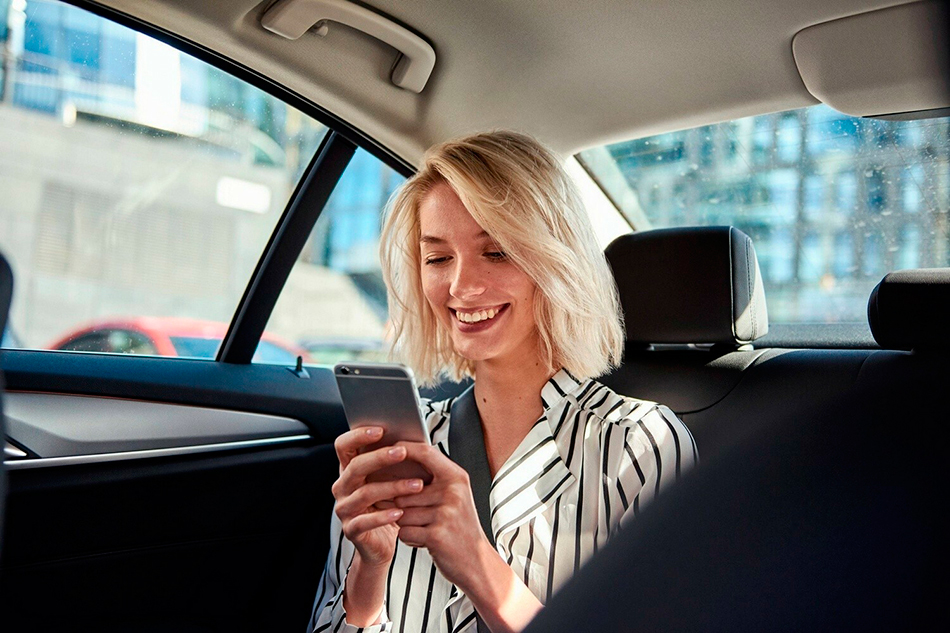 Дівчина оцінює якість поїздки у таксі через мобільний додаток з App Store