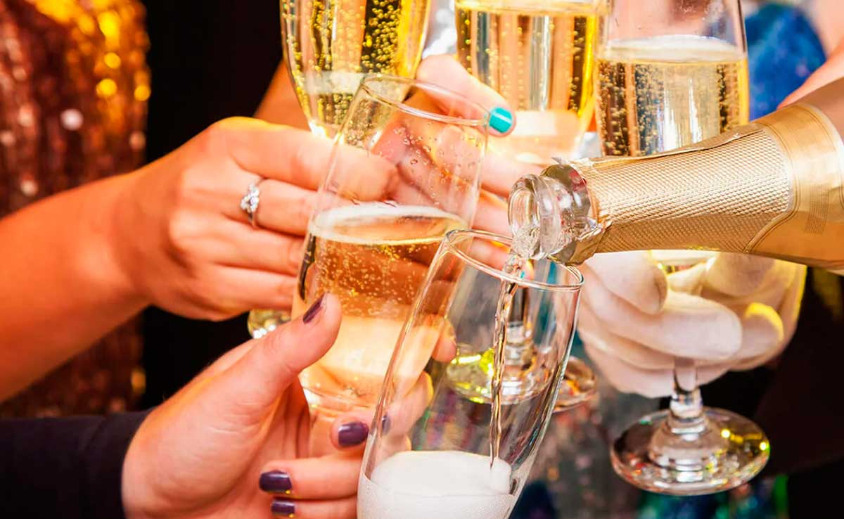 Игристое шампанское наливают в праздничные бокалы