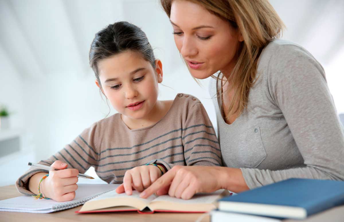 Мама допомагає робити домашнє завдання доньці