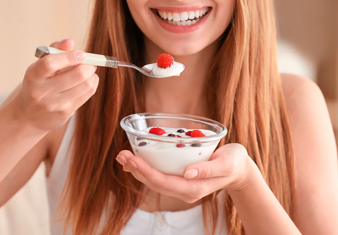 Девушка кушает натуральный пробиотик - йогурт