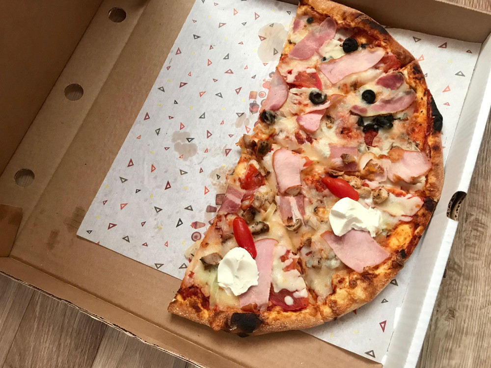 Половинка тонкої піци в коробці
