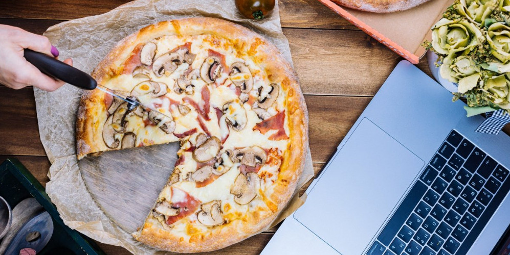 Нарізка піци біля ноутбука