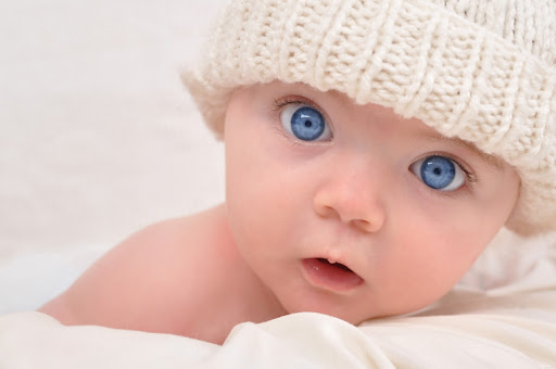 Новонароджений малюк у теплій шапочці