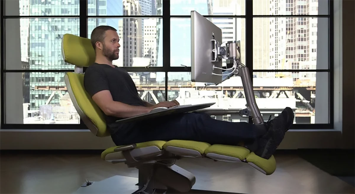 Чоловік зручно сидить у комп’ютерному кріслі