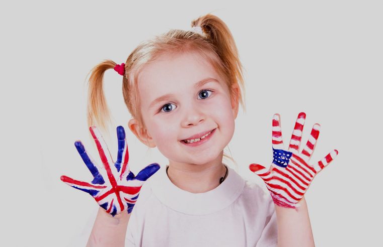 Американський та англійський прапори на руках дитини. Концепція вивчення англійської мови