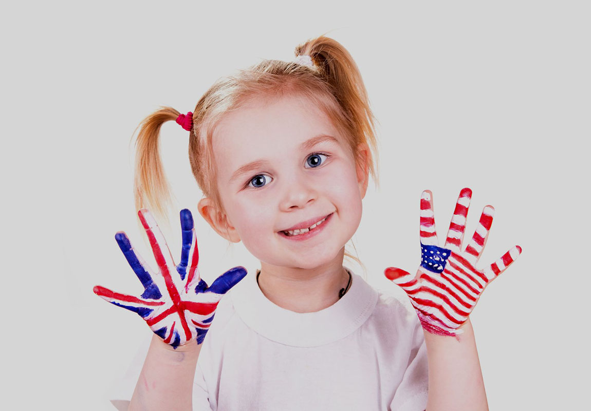 Американський та англійський прапори на руках дитини. Концепція вивчення англійської мови