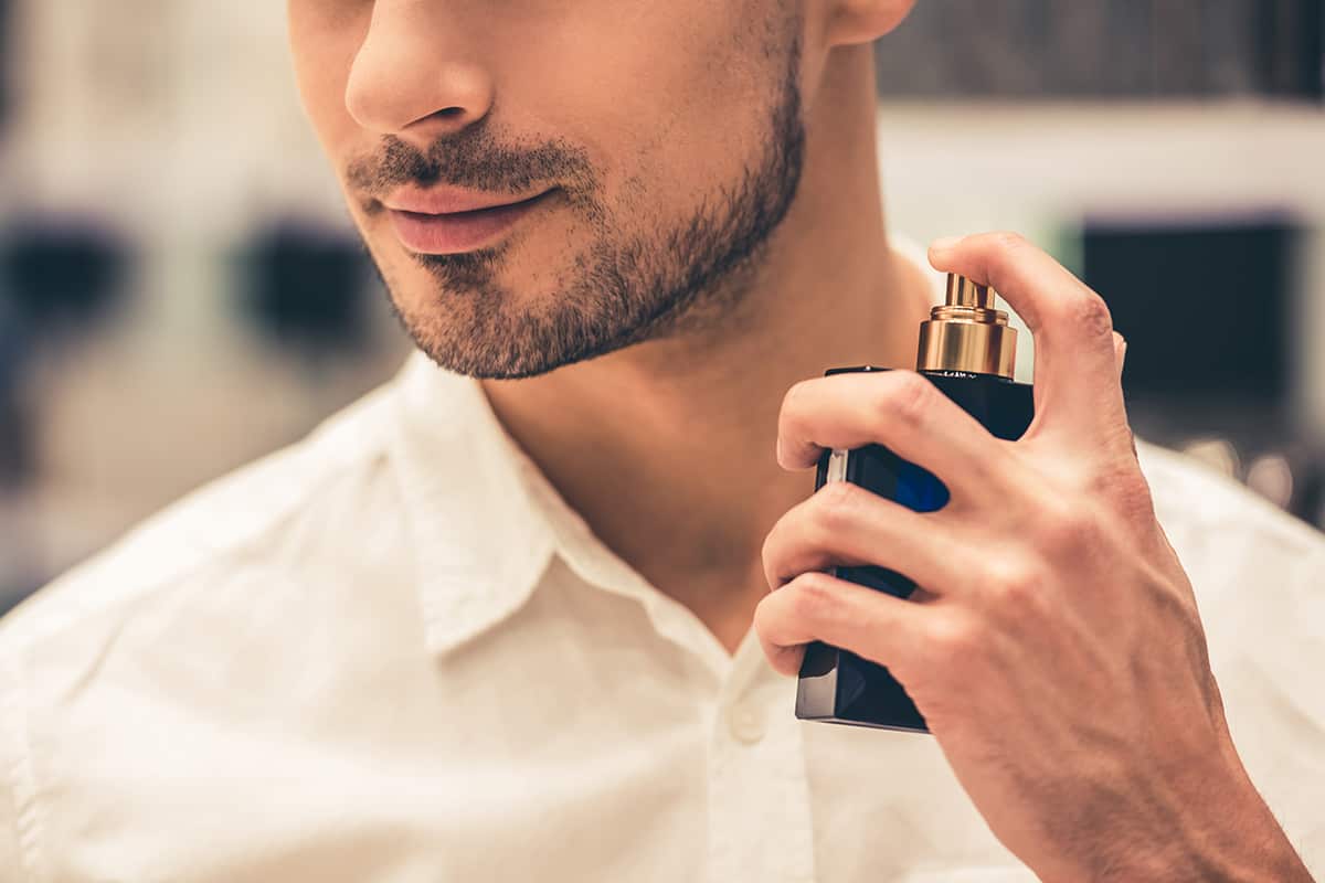 Мужчина с парфюмом в руке