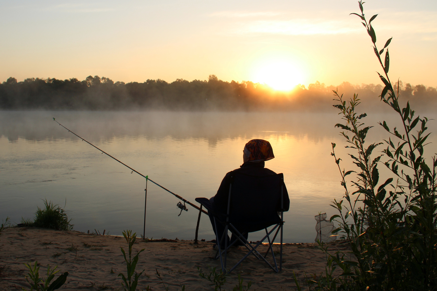 Рыбак на берегу пруда при восходе солнца (утренняя рыбалка)