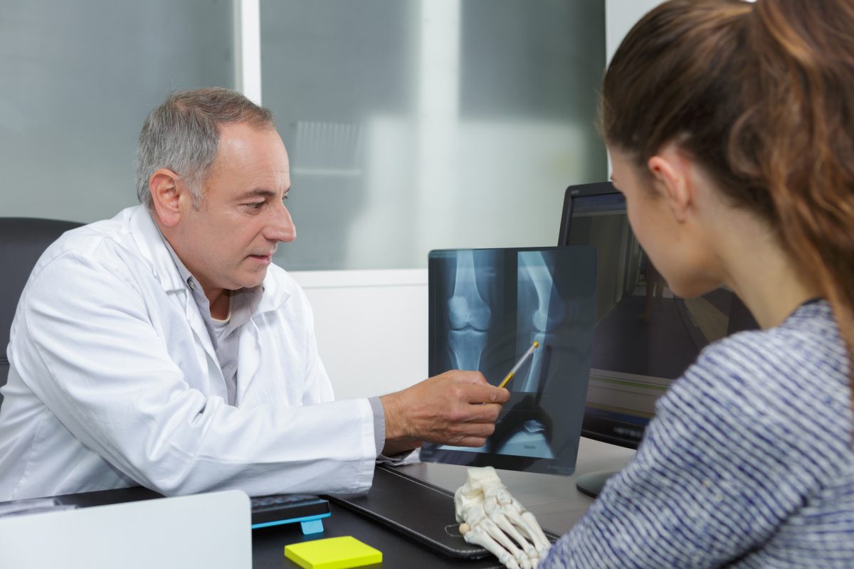 Ортопед показывает пациенту результаты рентгена